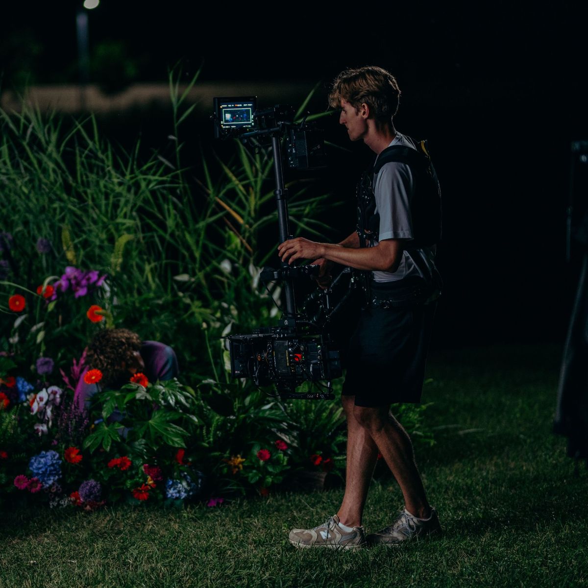 Daniel on the Steadicam at night beside a bed of flowers